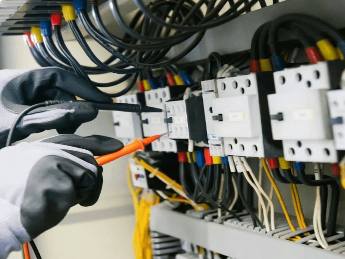 Elektriker som mäter i en elcentral